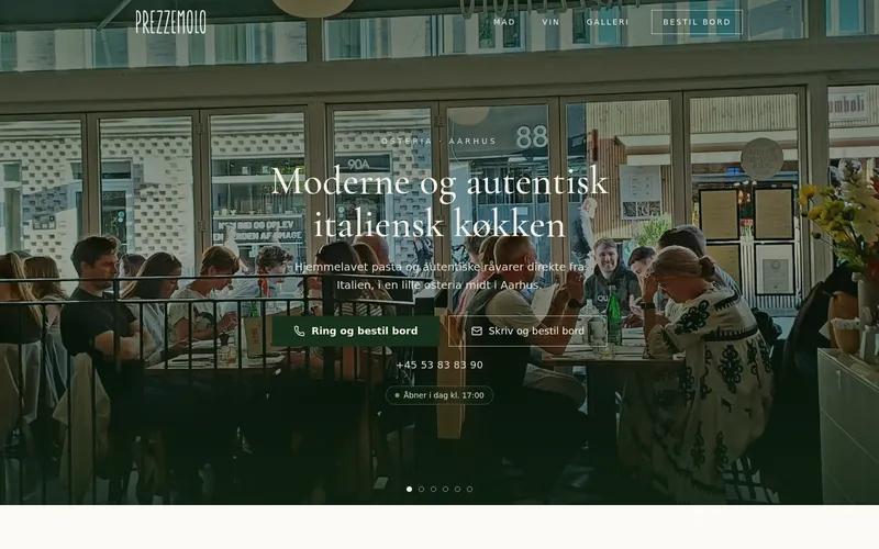 Startsidan för prezzemolo.dk: gäster vid borden i den lilla osterian, sedd genom de stora fönstren, med den danska rubriken ”Moderne og autentisk italiensk køkken”.